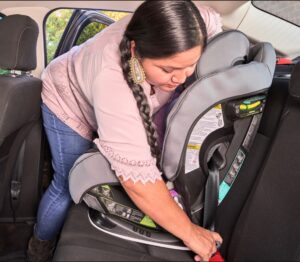 AI/AN caregiver installs a forward-facing child restraint.